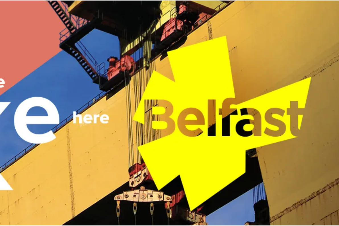 Belfast city branding reading “there’s no place like here”, over a photograph of a shipyard crane